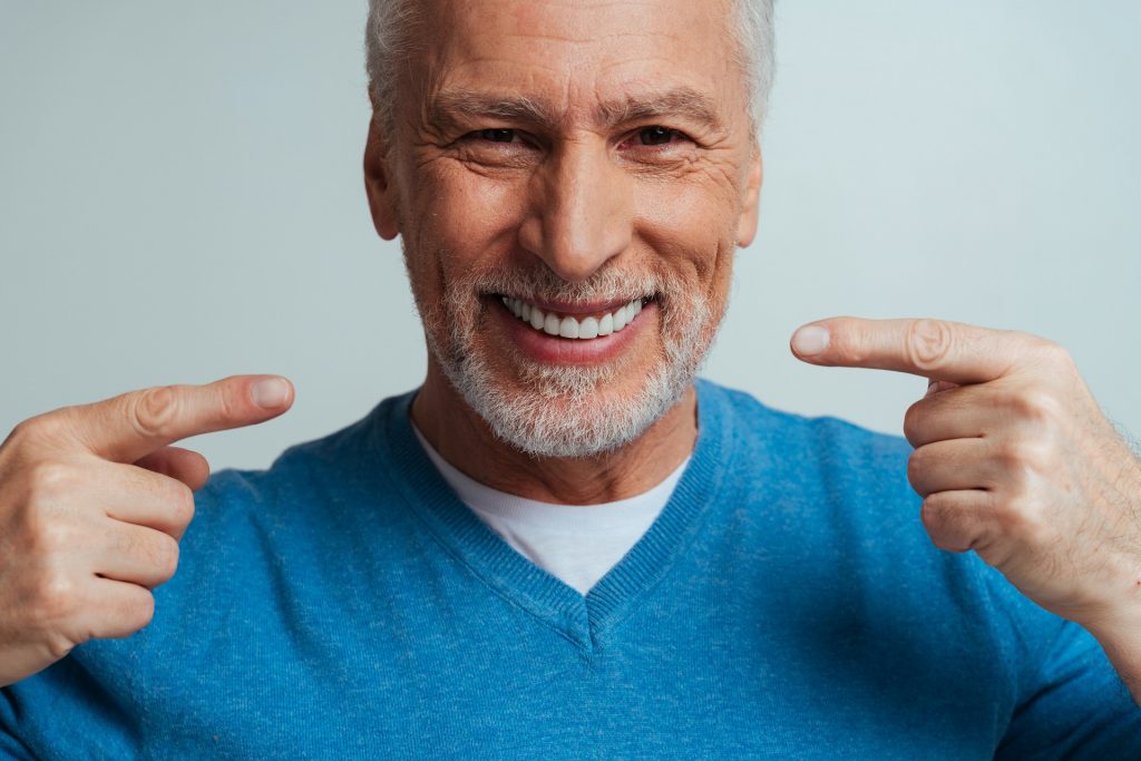 Old man pointing at his smile